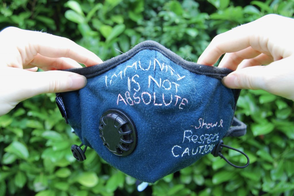 Photo of the mask held up at both sides by my pale, white hands.