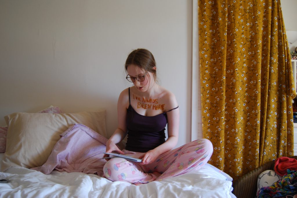 Picture of Sakara organising pieces of paper on her lap between photographs.