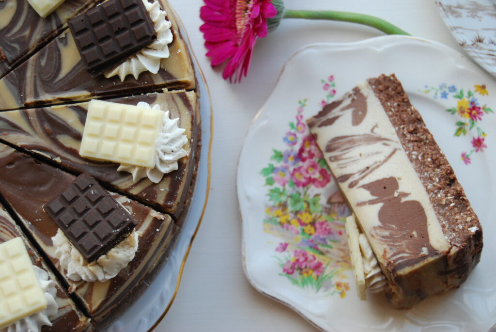 Photo of a brown and cream swirled cake laid out with a floral plate.