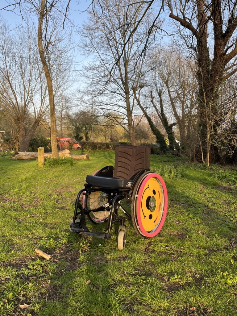 The wheelchair sits unoccupied in the sun.